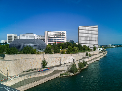 Basel, Switzerland - 10. May 2022: The Novartis compan with its new pavillion at the bank of the Rhine River. Novartis is a leading pharmaceutical company for medicine research and products.