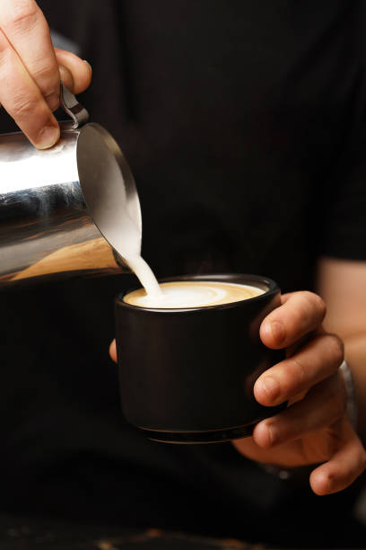 istock Barista pouring milk in coffee cup for make latte art 1397957770