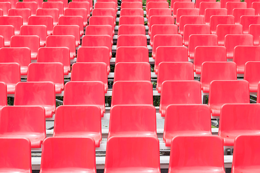 Rows of empty red grandstand seats, selective focus