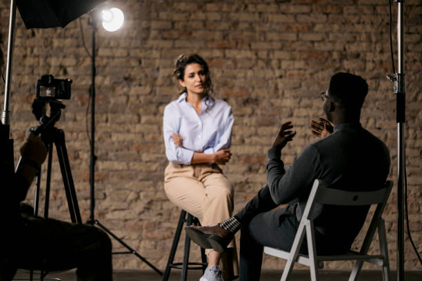 journalist interviewing a young woman in a studio - set goals imagens e fotografias de stock