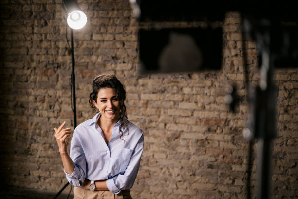 Young woman giving an interview in a studio Happy young woman giving an interview in a studio, smiling and gesturing with his hands while she is talking actress audition stock pictures, royalty-free photos & images