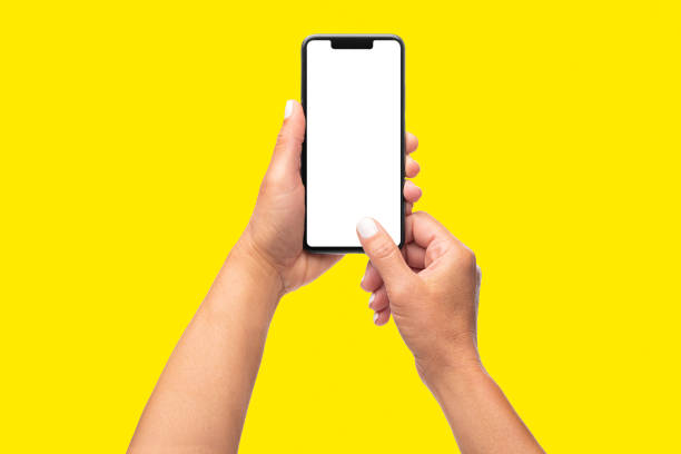 istock Hands holding mobile in vertical position with blank screen on yellow background 1397962177
