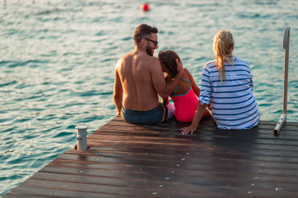 istock Parents and daughter enjoying sunset at seashore 1397964028