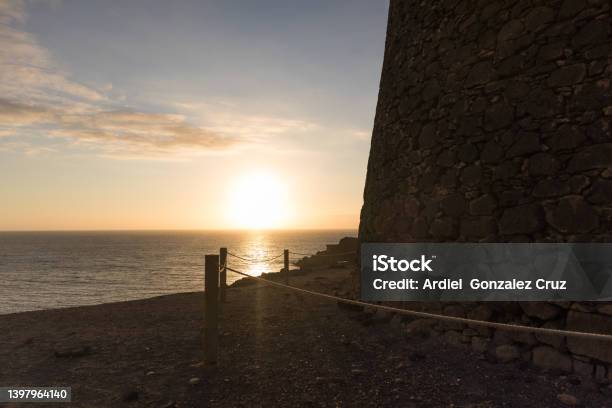 Beautiful Sunset Over The Sea From The Cliff With Old Castle On The Right El Cotillo Fuerteventura Canary Islands Spain Stock Photo - Download Image Now