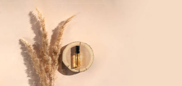 estandarte de un probador de perfumes glass con líquido marrón sobre una xilografía con pasto pampeano. vista superior - musk fotografías e imágenes de stock