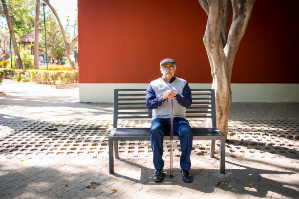 пожилой мужчина сидит на скамейке - one senior man only фотографии стоковые фото и изображения