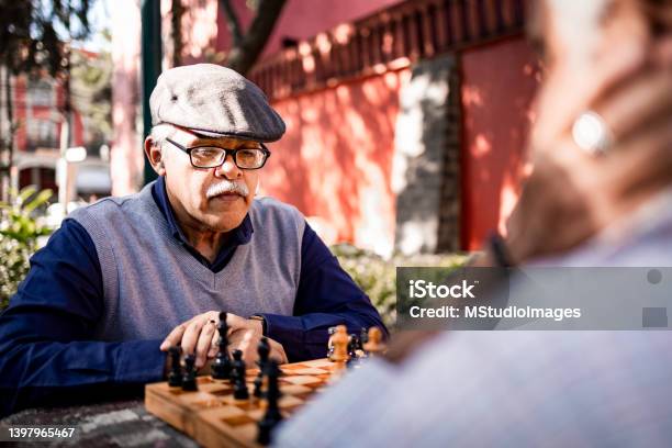 Two Senior Men Playing Chess Stock Photo - Download Image Now - Playful, Playing, Chess