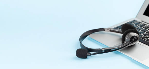 istock Headset over laptop on blue background 1397965801