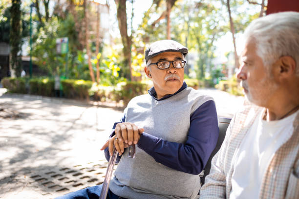 Two senior friends sitting and talking stock photo