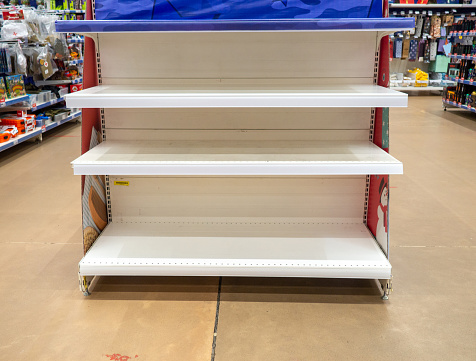 Empty shelves in the store. Laying out goods in a supermarket. Trade\