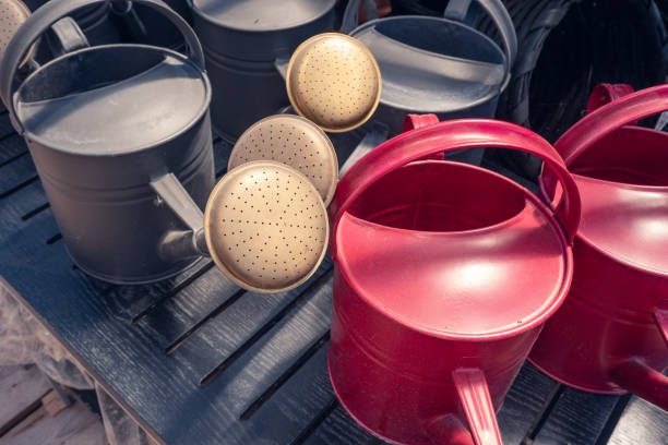 Close-up of red and grey retro design galvanized metal watering cans with long spout. Watering cans for outdoor or indoor house and garden plants.