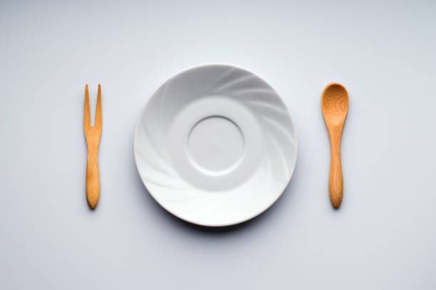 istock White plate, wooden fork and wooden spoon, flat lay 1397969280
