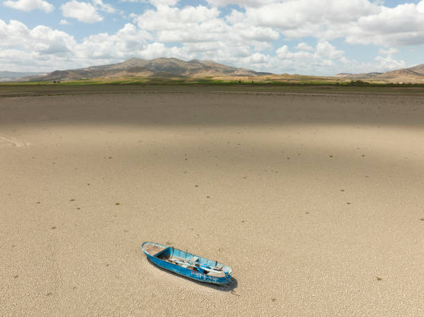 aerial view of a fishing boat on a drought dry lakebed. - lakebed imagens e fotografias de stock