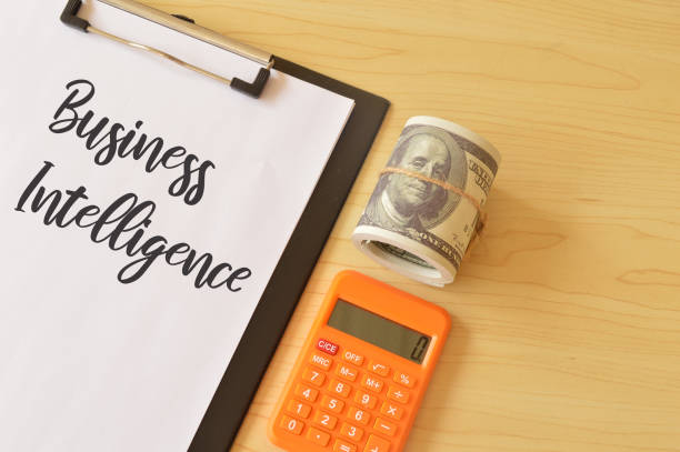 istock Money banknote, calculator and file with text BUSINESS INTELLIGENCE. 1397970912