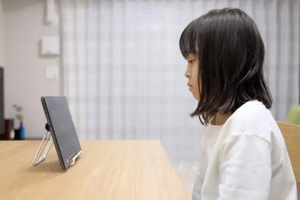 Japanese girl watching video on tablet PC (7 years old)