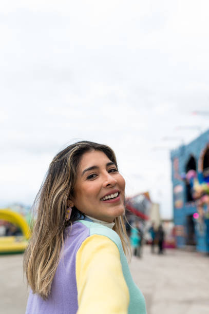 istock Smiling young woman looking at camera in amusement park 1397973347