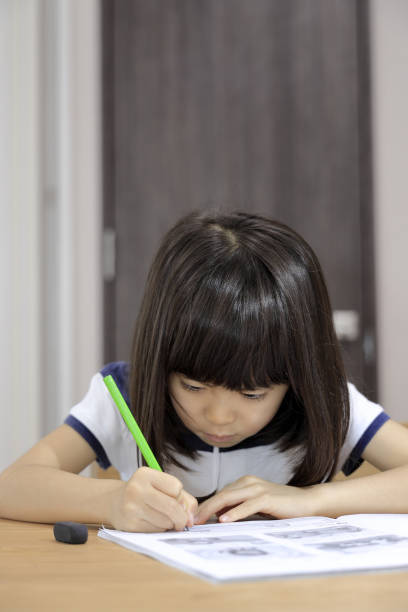 istock studying Japanese girl in dining room (7 years old) 1397973618