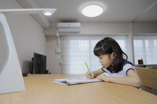 studying Japanese girl in dining room (7 years old)