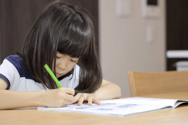 istock studying Japanese girl in dining room (7 years old) 1397973661