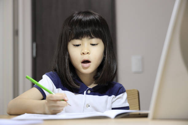 istock studying Japanese girl in dining room (7 years old) 1397973681