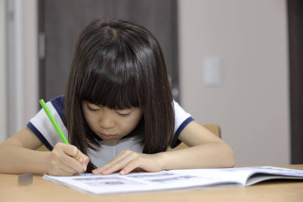 istock studying Japanese girl in dining room (7 years old) 1397973692