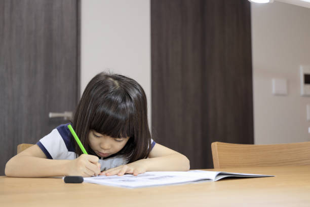 istock studying Japanese girl in dining room (7 years old) 1397974201
