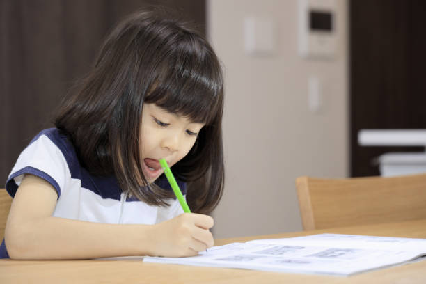 istock studying Japanese girl in dining room (7 years old) 1397974218