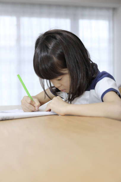 istock studying Japanese girl in dining room (7 years old) 1397974221