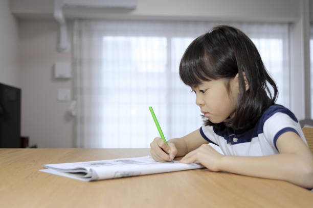 istock studying Japanese girl in dining room (7 years old) 1397974228