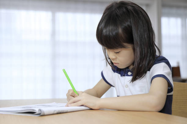 istock studying Japanese girl in dining room (7 years old) 1397974236
