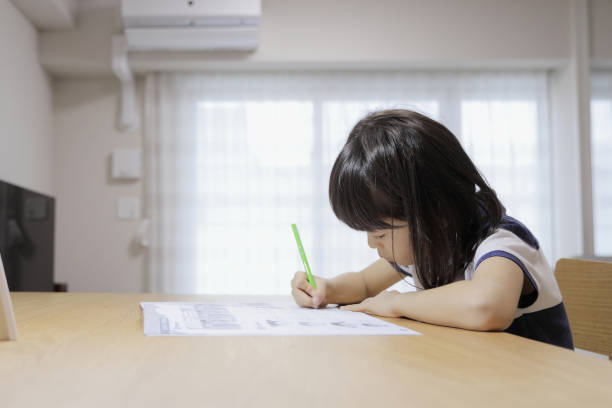 istock studying Japanese girl in dining room (7 years old) 1397974243