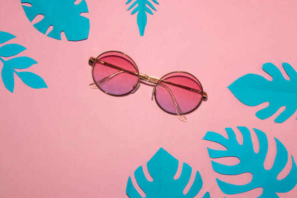 istock sunglasses on a pink background, around tropical blue leaves, creative summer concept 1397974464