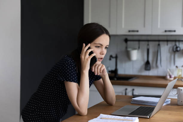 istock Serious woman standing in kitchen make call, talk on cellphone 1397974599