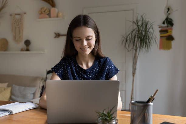 istock Woman smile look at laptop enjoy tech usage at home 1397975010