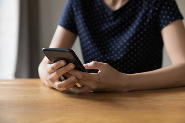 istock Closeup young female hands holding smartphone spend leisure on internet 1397975012