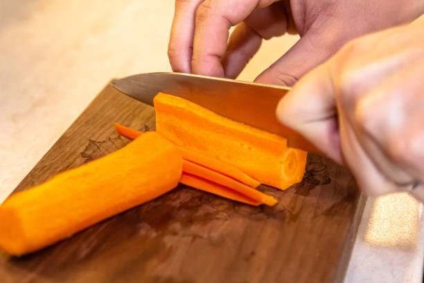 istock Chefs hands chopping carrot on wooden board 1397977443