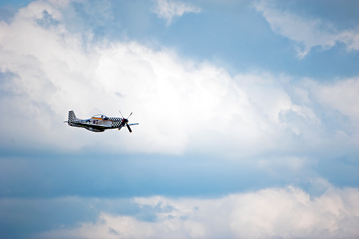 Small plane on blue cloudy sky background