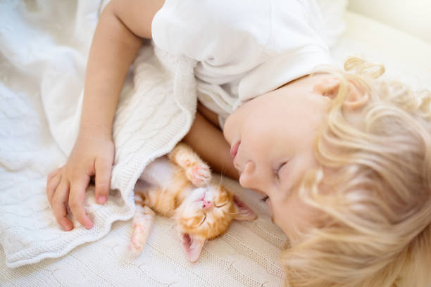 istock Baby boy sleeping with kitten. Child and cat. 1397982495