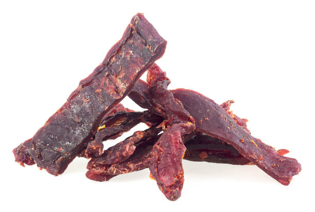 istock Portion of spiced beef jerky isolated on a white background. Dried peppered beef jerky. 1397982944