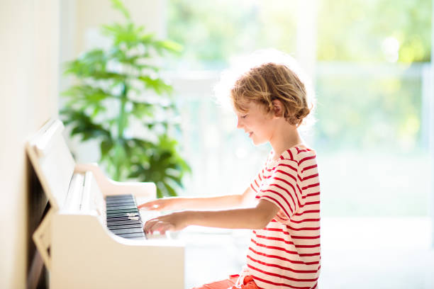 istock Child playing piano. Kids play music. 1397986327