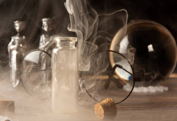 istock Small glasses with cork stopper with spices and empty, smoke, and more accessories, black background, selective focus. 1397991935