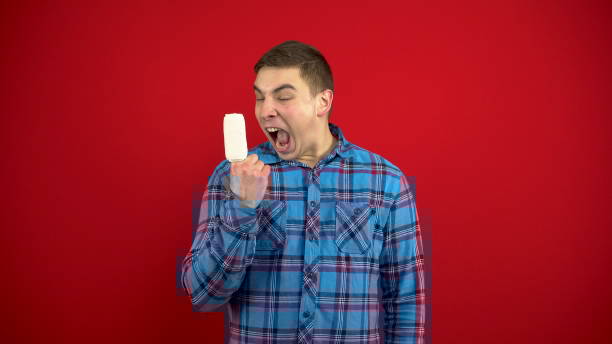 The young man's index finger is bandaged and sore. Shooting on a red background. The young man's index finger is bandaged and sore. Shooting on a red background. 4k pain points stock pictures, royalty-free photos & images