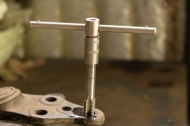 istock Cutting a thread in a hole with a tap by hand. Material high speed steel. We make an internal thread. 1397992225