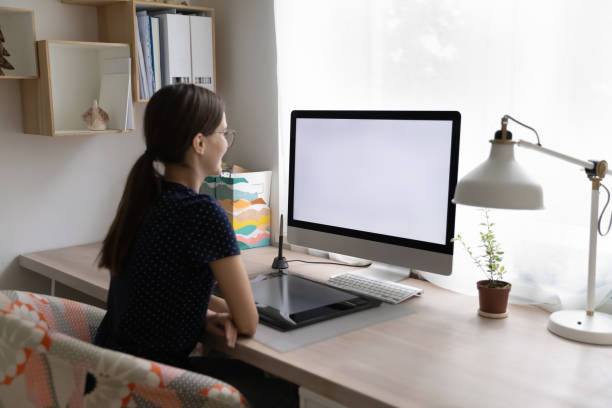 istock Woman sit at desk looks at PC white mockup screen 1397993295