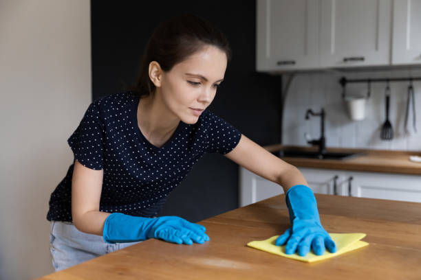 istock Young woman wear rubber gloves cleans kitchen table 1397993313