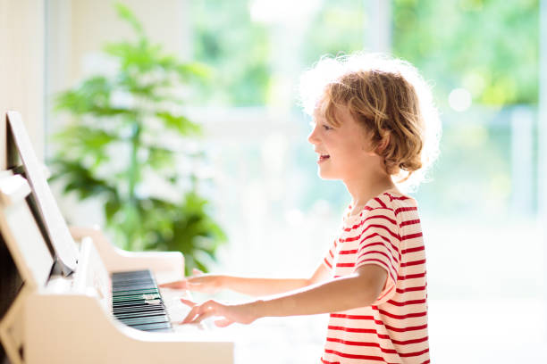 istock Child playing piano. Kids play music. 1397994505