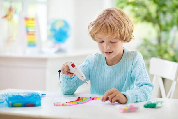 istock Crafts for kids. Child with hot glue gun. 1397994546
