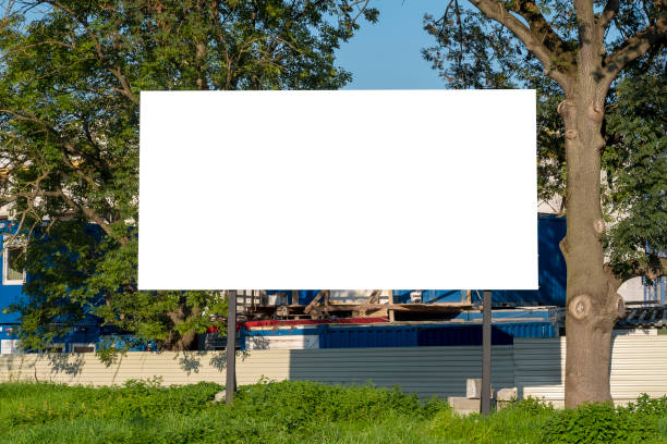 istock Advertising billboard mock-up in front of construction site, next to trees 1397994760