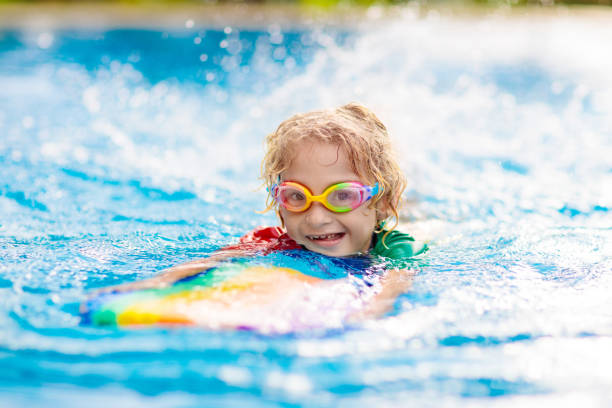 istock Child learning to swim. Kids in swimming pool. 1397996365