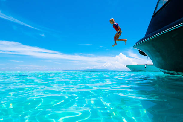 dziecko skacze do wody morskiej. wakacje jachtowe. - clear sky water sports and fitness yacht zdjęcia i obrazy z banku zdjęć